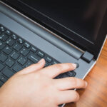 Persona che preme il tasto di accensione del pc ma non si accende