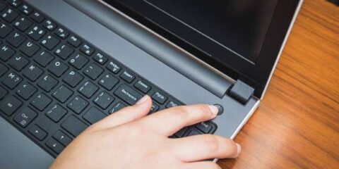 Persona che preme il tasto di accensione del pc ma non si accende