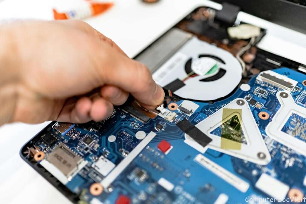 primo piano di un esperto di riparazione computer che sistema l'interno di un pc