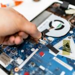 primo piano di un esperto di riparazione computer che sistema l'interno di un pc