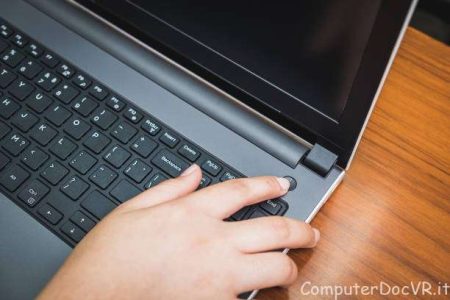 Persona che preme il tasto di accensione del pc ma non si accende